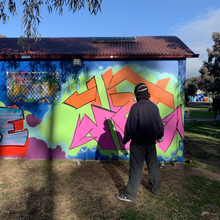 Banyule youth young person standing working on incomplete street art piece outdoors