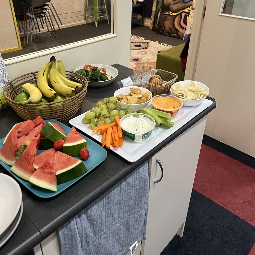 An arrangement of fruit, vegetables and dips on platters.